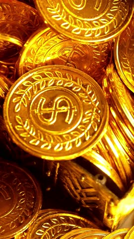 A macro close up pans over a large pile of shiny gold coins. The coins feature a dollar sign, symbolizing wealth, riches, and fortune.