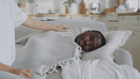 Careful wife covering her beloved sick husband by blanket in living room. Pandemic of virus, seasonal viral disease or depression, relax after dinner in weekend, dreaming in day for recovery energy - Powered by Shutterstock - Get 15% off with code: PIKWIZARD15