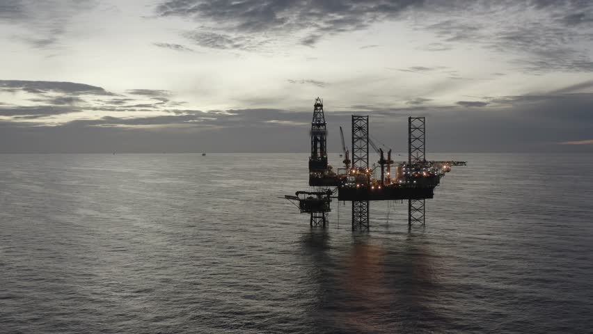 Aerial view of offshore jack up rig and offshore platform during sunset for oil and gas exploration and production. 

