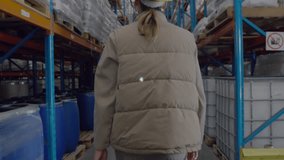 Warehouse inspector wearing helmet walking initiating digital IoT network overlay linking shelves. Industrial, connectivity, logistics, technology, automation, supply chain, distribution - Powered by Shutterstock - Get 15% off with code: PIKWIZARD15