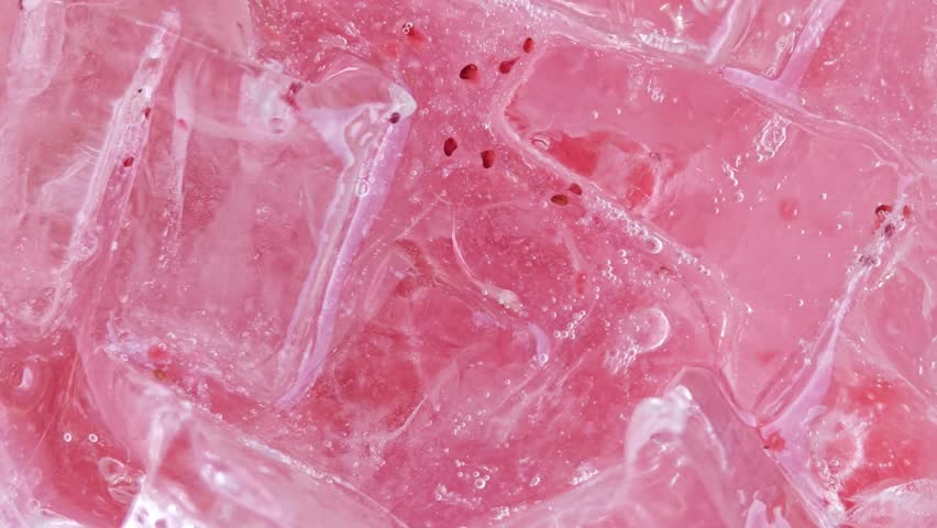 Ice cubes with bubbles of pink lemon soda.