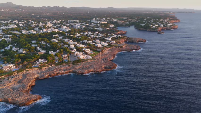 Aerial Sunrise Over Cala d'Or: Multiple Coves, Yachts, and Resort Town on Mallorca's Coast