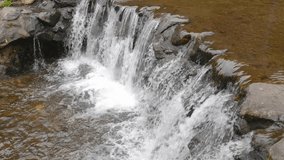 Looped footage of clear mountain water cascading over stones with white foam and brown riverbed tones, perfect for relaxation and nature backgrounds - Powered by Shutterstock - Get 15% off with code: PIKWIZARD15