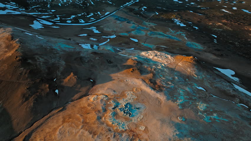 Drone footage of geothermal vents in Hverir area, North Iceland. The volcanic ground emits steam and sulfur gas under evening light.