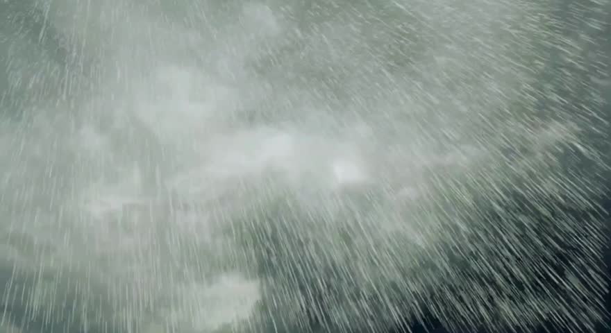 A dramatic view of heavy rain falling from a dark, cloudy sky, creating a sense of intensity and the raw power of nature