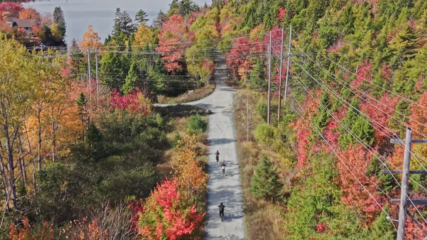 Group Of Cyclists Riding Forest Trail Near Lake Halifax Nova Scotia.Colorful Autumn Day In Beechville Shows Bikers Riding Along Scenic Lakeside Trail Surrounded By Fall Colors