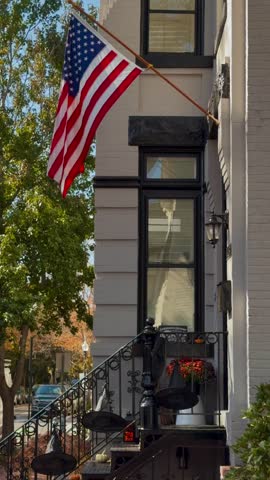 American flag above the stoop of a townhouse along a residential street. January 16, 2019