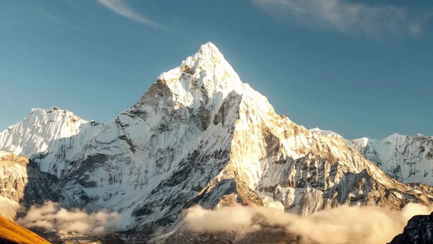 Stunning alpine mountains blanketed in snow beneath a crisp blue sky, showcasing the grandeur and tranquility of a winter landscape.