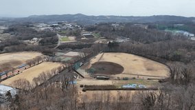 Drone descends toward a baseball field in Hadano, Japan, capturing players practicing, cityscape, and surrounding mountains. Ideal for sports, training, or outdoor videos. - Powered by Shutterstock - Get 15% off with code: PIKWIZARD15