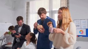 Group of young professionals enjoying sandwiches and coffee in office kitchen. Informal business lunch break, teamwork and friendly communication. - Powered by Shutterstock - Get 15% off with code: PIKWIZARD15