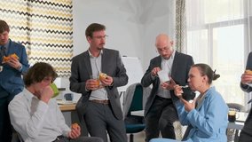 Beautiful young woman in blue suit eating salad among male colleagues during office lunch break. Relaxed teamwork, informal atmosphere, coworkers enjoying food and drinks together. - Powered by Shutterstock - Get 15% off with code: PIKWIZARD15