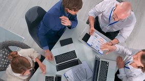 Top view of business team in office sharing printed charts, diagrams and data analysis. Colleagues with laptops review financial statistics and market indicators, collaborating on investment planning. - Powered by Shutterstock - Get 15% off with code: PIKWIZARD15