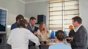 Group of business colleagues standing in office kitchen, drinking coffee, juice and eating snacks during break. Relaxed teamwork, friendly atmosphere, informal lunch moment. - Powered by Shutterstock - Get 15% off with code: PIKWIZARD15