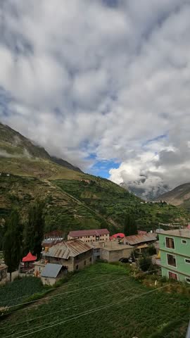 Scenic view of the mountains and valley surrounding Keylong, India, filmed from a rooftop, showing the beauty and calm of the Himalayas.