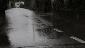 Dark urban street at night during rainfall, wet pavement reflecting streetlights, empty sidewalks, and a moody atmospheric scene - Powered by Shutterstock - Get 15% off with code: PIKWIZARD15