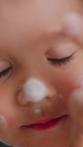 adorable child experiences gentle cosmetic application, young child responds with smiles during soft makeup