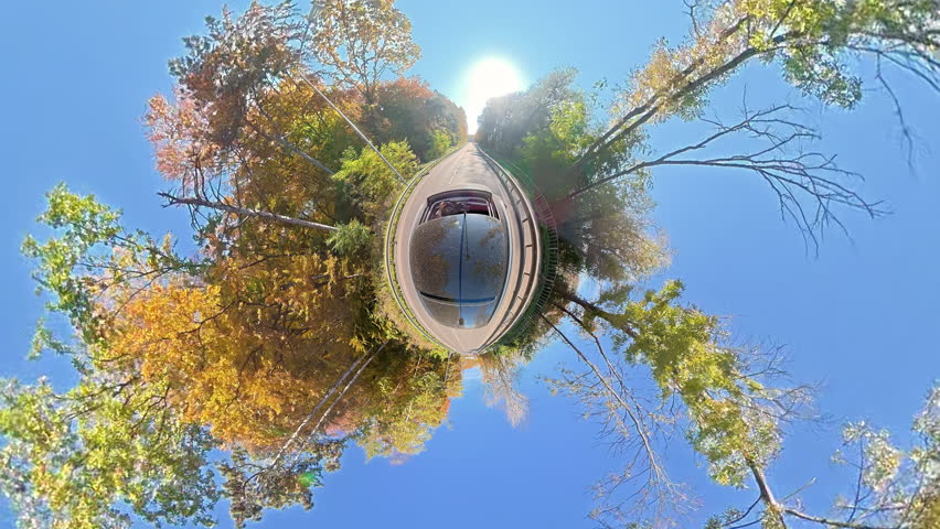 Scenic tiny planet view 360 panorama of a road trip in autumn, Spherical perspective from a car with colorful trees and blue sky