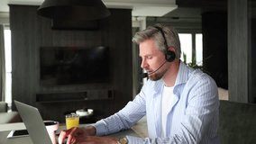 Businessman wearing headset working in home to support remote customer or colleague. Call center, telemarketing, customer support agent provide service on telephone video conference call - Powered by Shutterstock - Get 15% off with code: PIKWIZARD15