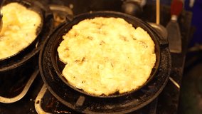 Crispy fried omelette cooking in cast iron skillet, showcasing golden brown texture and bubbling edges, lifted with slotted spatula for delicious breakfast food experience - Powered by Shutterstock - Get 15% off with code: PIKWIZARD15