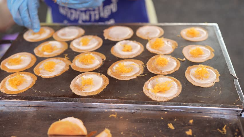 Delightful Thai Street Food Traditional Pancakes Topped with Sweet Golden Threads, Culinary Snack Experience with Vibrant Colors and Textures at Local Food Stalls