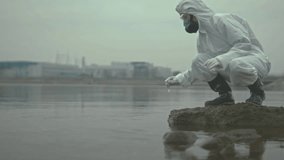 A scientist collects water samples in protective gear to examine contamination levels after an eco disaster.
 - Powered by Shutterstock - Get 15% off with code: PIKWIZARD15