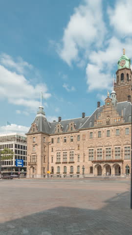 Hyperlapse of Rotterdam City Hall (Stadhuis van Rotterdam) at Coolsingel. One of the few historic buildings in the city center timelapse. Traffic and people on the street, cloudy blue sky. Netherlands
