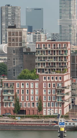 Aerial timelapse of modern buildings in Rotterdam city center, The Netherlands. Towers and skyscrapers in the financial district with warm morning light creating a vibrant skyline. Ships on waterfront