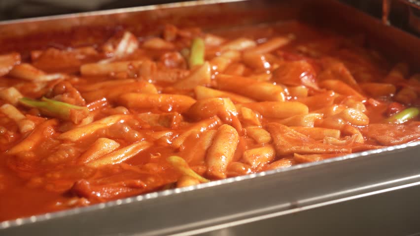 Sweet and spicy rice cake with seaweed roll in a baking tray.