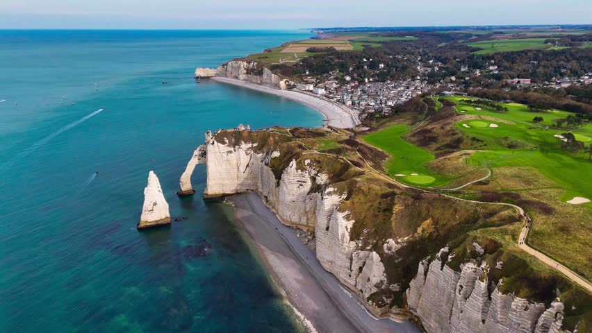 Aerial drone view of picturesque coastal limestone cliffs and the English Channel town of Etretat, France. High quality 4k footage