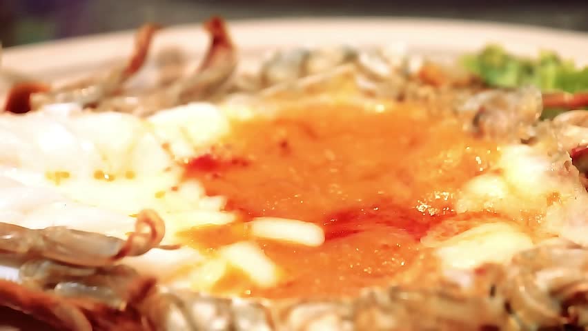 King giant prawns grilled - large juicy prawns barbecued over open flame with smoky butter glaze. The chef grills them to golden perfection, capturing sizzling texture, luxurious seafood delicacy food