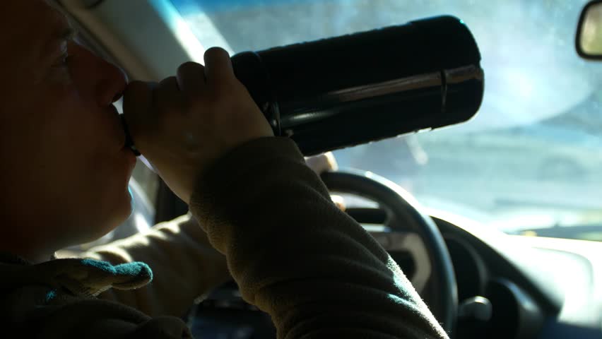 Drunk driving. The driver drinks whiskey while driving. The driver drinks strong alcohol while driving.