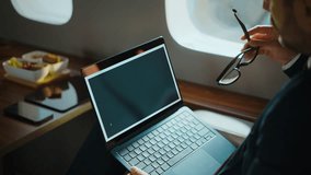 Successful businessman analyzing stock market data and forex exchange financial graphs on his laptop computer while traveling on a comfortable luxury private jet for a business trip - Powered by Shutterstock - Get 15% off with code: PIKWIZARD15