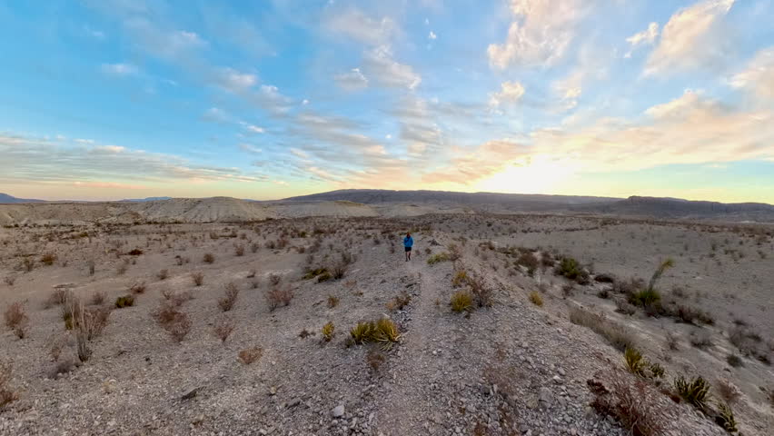Man Hikes Across Flat Desert at Sunrise in Big Bend National Park