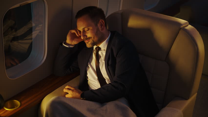 Wealthy businessman sleeping comfortably in a first-class seat on a private jet during a night flight, enjoying the luxury and comfort of air travel after a long and tiring work trip