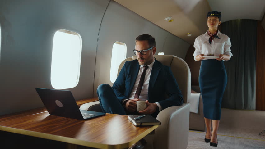 Smiling flight attendant serving a happy businessman a slice of cake during a comfortable and luxurious first-class flight on a private jet, creating a premium travel experience