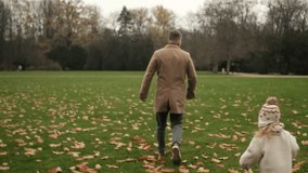 Run in an autumn park: a father leads his child across a green lawn, his feet crunching through the leaves. Autumn colours, a playful sprint, healthy movement, shared joy, simple connection - Powered by Shutterstock - Get 15% off with code: PIKWIZARD15