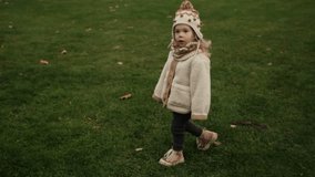 Walk in autumn park: father holding child's hand and walking across lawn. Autumn park, autumn breeze, warm clothes, close connection, tender parenting, peaceful family scene - Powered by Shutterstock - Get 15% off with code: PIKWIZARD15