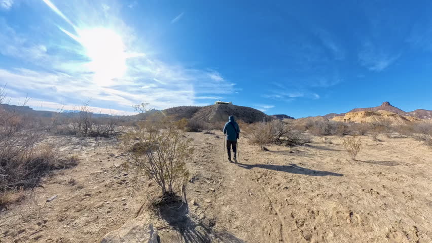 Man Treks with Poles Across Flat Desert in Big Bend