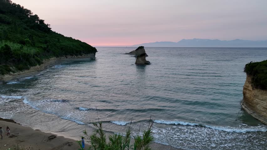 Aerial drone footage flying over the beach and sea stacks of Canal d'Amour, Sidari. A beautiful, calm sunset over the Ionian Sea, Corfu, Greece