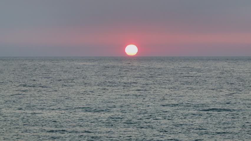 Cinematic drone pan revealing the iconic sea stacks of Canal d'Amour, Sidari, as the vibrant sun sets over the calm Ionian Sea. Corfu, Greece
