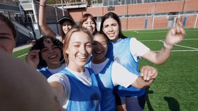 Group of excited multiethnic female soccer players celebrating their victory on a sunny day at the stadium, taking a selfie video together while cheering, laughing, and smiling at the camera - Powered by Shutterstock - Get 15% off with code: PIKWIZARD15