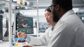 Multiracial lab engineers inspect liquids in test tube, looking for breakthroughs during clinical trials. Asian and African american men comparing chemicals vials, testing formula, camera B - Powered by Shutterstock - Get 15% off with code: PIKWIZARD15