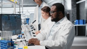 Portrait of happy scientist typing on keyboard, using computer program for DNA data analysis in laboratory driving treatment discovery. Jolly researcher using bioinformatics software in lab, camera B - Powered by Shutterstock - Get 15% off with code: PIKWIZARD15