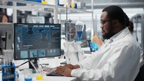 Portrait of smiling laboratory scientist using computer monitor, processing DNA patient data for clinical research. Cheerful african american lab worker looking at analysis diagnostics on PC, camera B - Powered by Shutterstock - Get 15% off with code: PIKWIZARD15