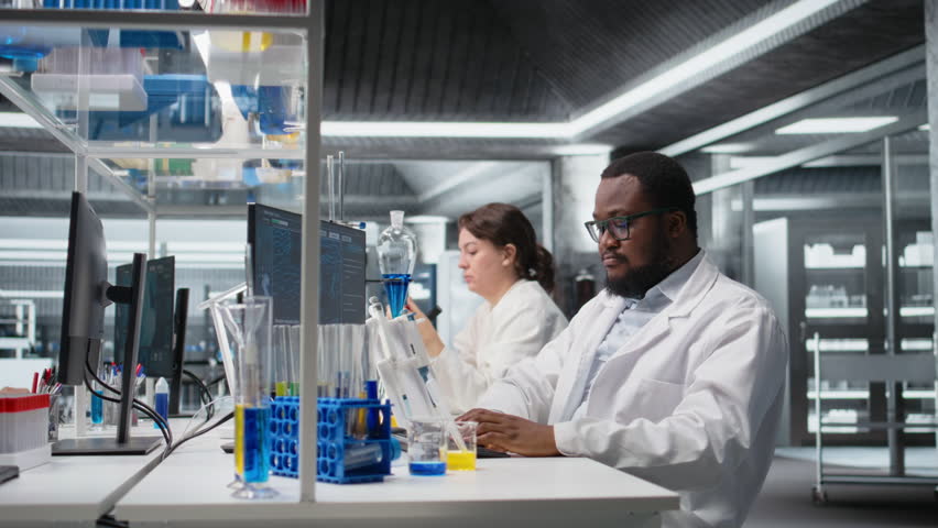 Portrait of smiling laboratory scientist using computer monitor, processing DNA patient data for clinical research. Cheerful african american lab worker looking at analysis diagnostics on PC, camera A - Powered by Shutterstock - Get 15% off with code: PIKWIZARD15