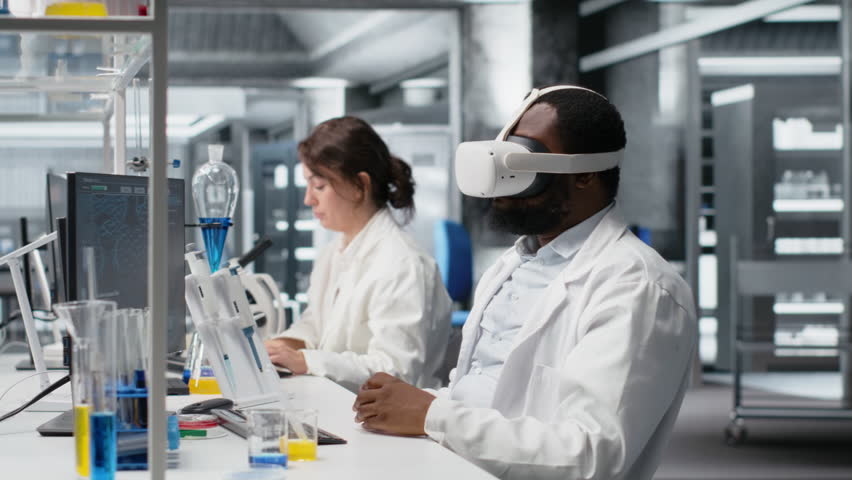Scientist using computer and VR headset equipment for DNA data analysis in laboratory. African american man using bioinformatics genomics software and virtual reality tech in modern lab, camera B - Powered by Shutterstock - Get 15% off with code: PIKWIZARD15