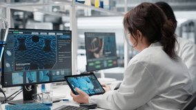 Laboratory manager and trainee using tablet app to process DNA patient data for clinical research. Lab team leader and intern use device to do lab genetic analysis diagnostics, camera B - Powered by Shutterstock - Get 15% off with code: PIKWIZARD15