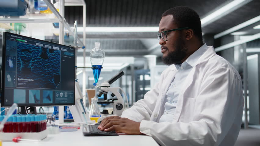 Laboratory worker squinting eyes at computer monitor, struggling to understand DNA data. African american lab expert unable to believe eyes while looking at genetic analysis diagnostics, camera A - Powered by Shutterstock - Get 15% off with code: PIKWIZARD15