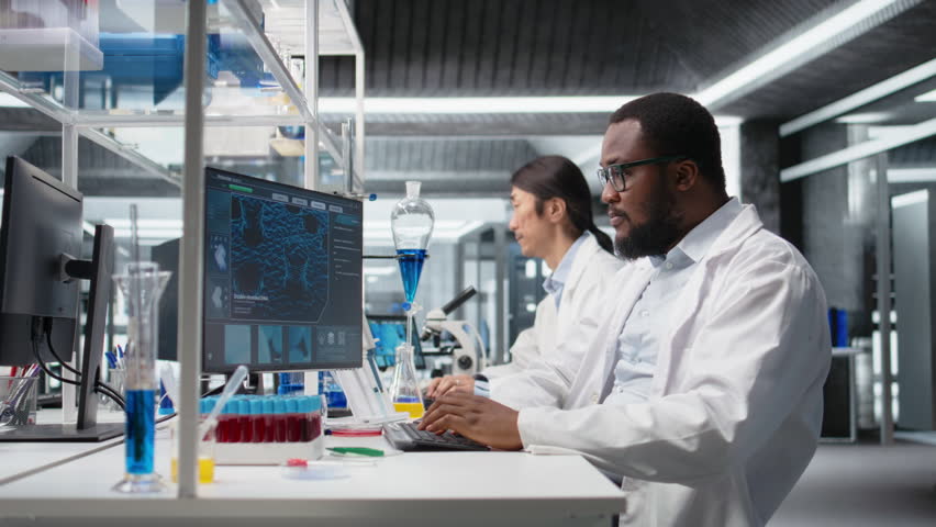 Molecular biologist uses computer program displaying DNA data, removing eyeglasses. African american man confused by bioinformatics genomics software analysis on PC in lab, camera A