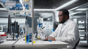 Chemist uses pipette to transfer liquid into test tube containing blue solution at laboratory bench. African american man in research facility does pipetting procedure with chemical reagent, camera A - Powered by Shutterstock - Get 15% off with code: PIKWIZARD15